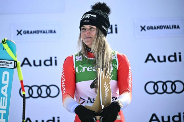 First-placed Switzerland's Corinne Suter holds her trophy on the podium after winning the women's downhill race, part of the FIS Alpine Ski World Cup 2025-2026 in Soldeu, Andorra on February 26, 2026. (Photo by Lionel BONAVENTURE / AFP)
