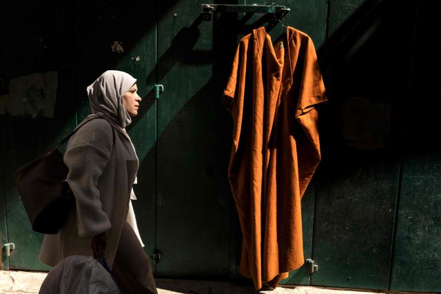 TOPSHOT - A Muslim worshipper makes her way past a closed shop to the Aqsa mosque ahead of the second Friday noon prayers of the holy month of Ramadan in the old city of Jerusalem on February 27, 2026. Muslims throughout the world are marking the month of Ramadan, the holiest month in the Islamic calendar, during which devotees fast from dawn until dusk. (Photo by JOHN WESSELS / AFP)