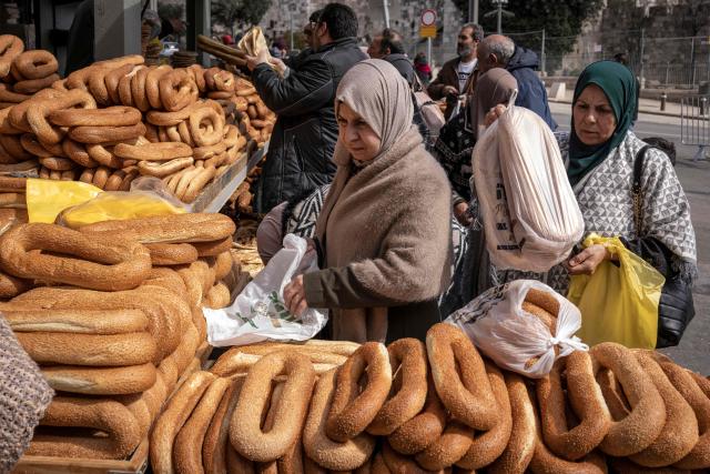TOPSHOT - A woman shops for bread from a bakery after the second Friday noon prayers of the holy month of Ramadan in the old city of Jerusalem on February 27, 2026. Muslims throughout the world are marking the month of Ramadan, the holiest month in the Islamic calendar, during which devotees fast from dawn until dusk. (Photo by JOHN WESSELS / AFP)