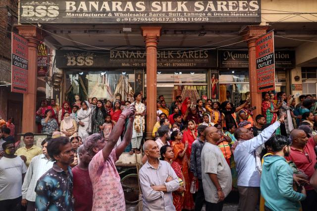 People gather to watch a religious procession during 'Masaan' or 'Bhasma' Holi, celebrated with ashes of the pyre, in Varanasi on February 27, 2026. (Photo by Niharika KULKARNI / AFP)