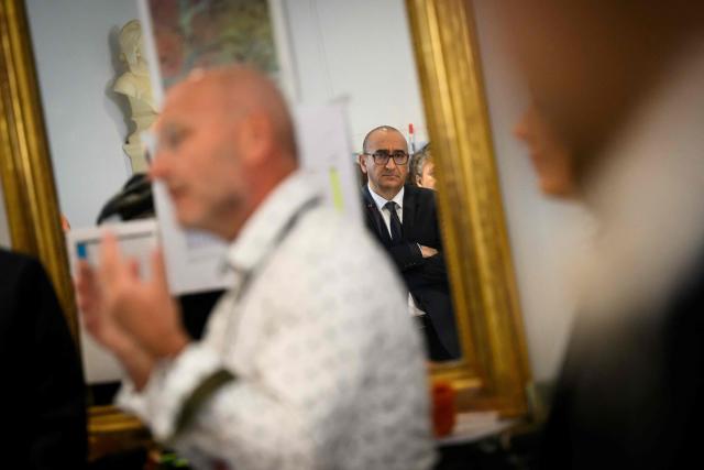 French Interior Minister Laurent Nunez (C) listens to mayor of Cheffes Marc Dutruel (L) at the city hall during a visit focused on the consequences of the floods on February 27, 2026. (Photo by Loic VENANCE / AFP)