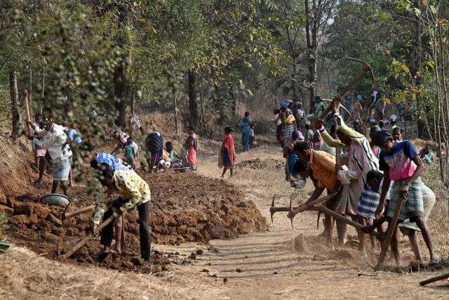 This photograph taken on February 14, 2026 shows wage-labourers under Mahatma Gandhi National Rural Employment Guarantee Act (MGNREGA) toiling a dirt road at a road-construction site at Balapur Dolkarpada village in Maharashtra's Palghar district. India's economy grew at a faster pace than expected in the last quarter of 2025 driven by solid consumer spending, data showed on February 27, using a new framework that calculates economic output more accurately. (Photo by Indranil Mukherjee / AFP)