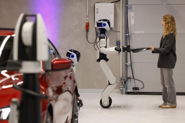 AEON, a humanoid robotic created by the company Hexagon, gives over a piece for a car as it is presented by BMW, at their BMW Group Talent Campus in Munich, Bavaria, southern Germany, on February 27, 2026. (Photo by Michaela STACHE / AFP)