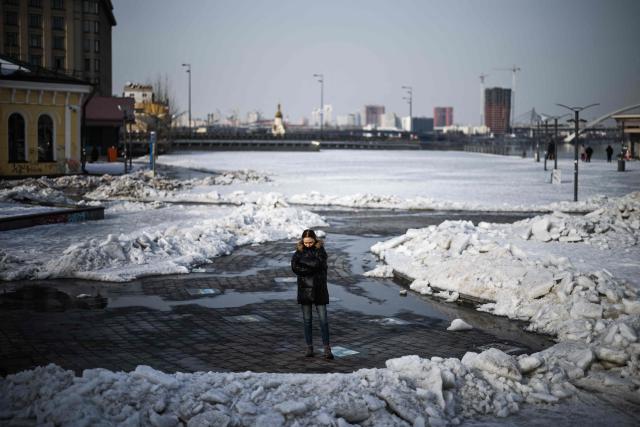 A memner of the public stands near to the bank of the Dnieper river in the Podil district of Kyiv on February 27, 2026, amid the Russian invasion of Ukraine. (Photo by HENRY NICHOLLS / AFP)