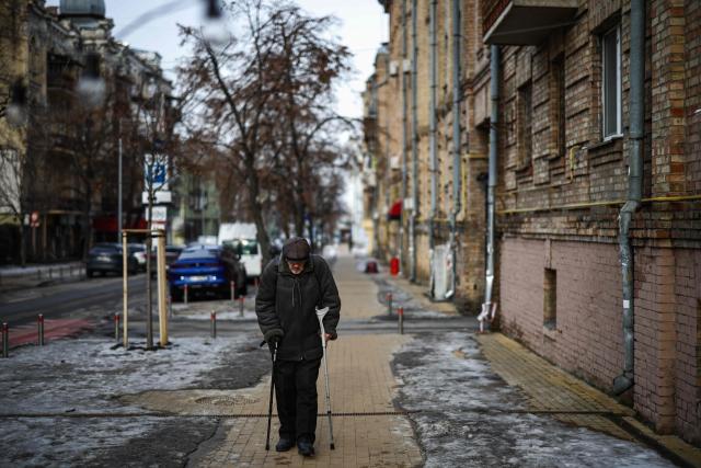 EDITORS NOTE: Graphic content / A pedestrian walks using crutches walks in the Podil district of Kyiv on February 27, 2026, amid the Russian invasion of Ukraine. (Photo by HENRY NICHOLLS / AFP)