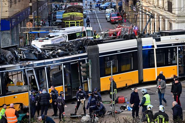 Italian police officers and firefighters operate at the site of a tram derailment in Milan on February 27, 2026. A tram derailed and smashed into a building in Milan on February 27, 2026, killing one person and injuring around 20 others, the police told AFP. (Photo by Piero CRUCIATTI / AFP)