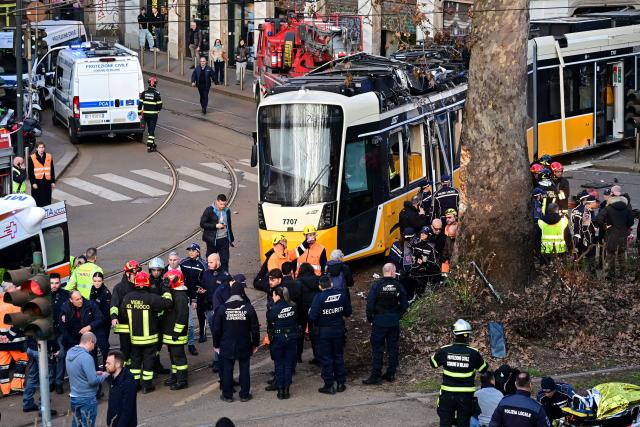 Italian police officers and firefighters operate at the site of a tram derailment in Milan on February 27, 2026. A tram derailed and smashed into a building in Milan on February 27, 2026, killing one person and injuring around 20 others, the police told AFP. (Photo by Piero CRUCIATTI / AFP)