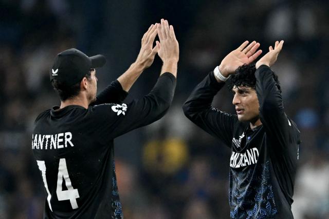 New Zealand's Rachin Ravindra (R) celebrates with captain Mitchell Santner after taking the wicket of England's Sam Curran during the 2026 ICC Men's T20 Cricket World Cup Super Eights match between England and New Zealand at the R Premadasa Stadium in Colombo on February 27, 2026. (Photo by Ishara S. KODIKARA / AFP)