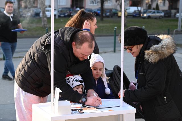 A supporter collects signatures for Hungary's ruling FIDESZ party spokesperson Balazs Nemeth during a campaign in one of Budapest's outer districts on February 27, 2026. (Photo by Attila KISBENEDEK / AFP)