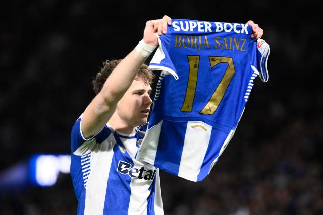 FC Porto's Polish midfielder #77 Oskar Pietuszewski holds up teammate FC Porto's Spanish forward #17 Borja Sainz's jersey as he celebrates scoring the opening goal during the Portuguese League football match between FC Porto and FC Arouca at Dragao stadium in Porto, on February 27, 2026. (Photo by Miguel RIOPA / AFP)