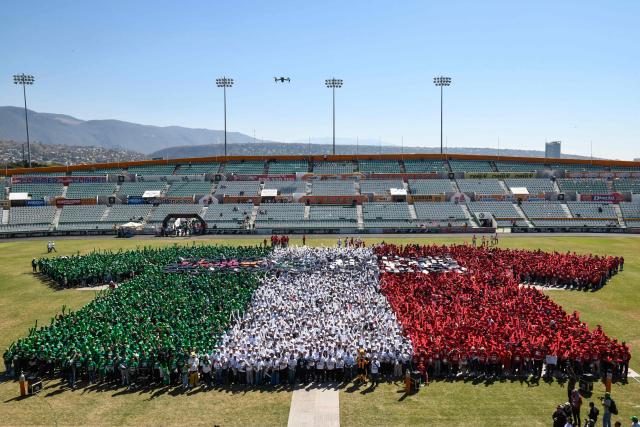 Football fans take part in forming a mosaic of a jersey in Mexico's flag colors that aims to be the largest in the world and enter the Guinness Book of Records, with about five thousand people, in Tuxtla Gutierrez, Chiapas state, Mexico, on February 27, 2026. (Photo by Isaac GUZMAN / AFP)
