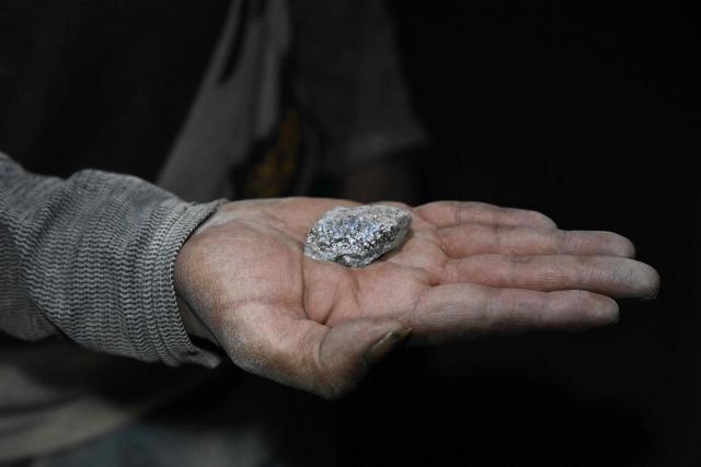 A miner shows a piece of silver inside a tunnel of the Rosario Bajo Cooperativa Minera on Cerro Rico, in the Potosi Department, in southern Bolivia, on February 19, 2026. With silver prices reaching record levels, miners continue to risk their lives inside Bolivia's Cerro Rico mine, following veins to exploit deposits of the metal, along with other minerals, in this overworked, collapsing mountain that once produced the majority of silver for the Spanish Empire. Today Cerro Rico is the underground workplace of thousands of miners, as Bolivia's silver output increases year after year. (Photo by Aizar RALDES / AFP)
