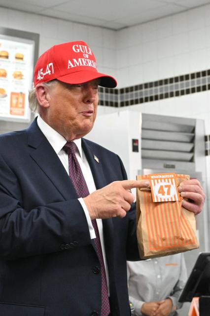 US President Donald Trump holds a bag of food in a Whataburger restaurant in Corpus Christi, Texas, on February 27, 2026. (Photo by Mandel NGAN / AFP)