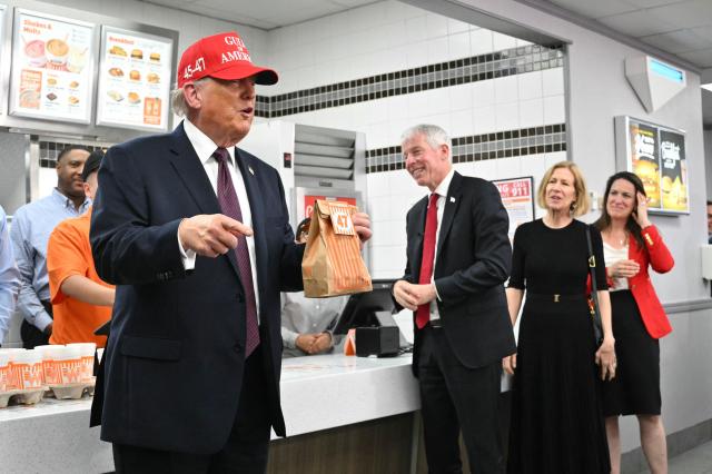 US President Donald Trump holds a bag of food in a Whataburger restaurant in Corpus Christi, Texas, on February 27, 2026. (Photo by Mandel NGAN / AFP)