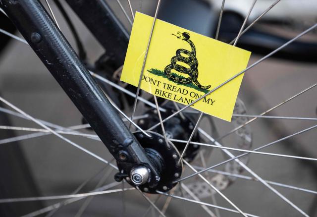 A card is seen between spokes as cyclists rally for bicycle safety in Washington, DC, on February 27, 2026. The Washington Area Bicyclist Association organized a demonstration after federal agencies considered removing a section of the 15th Street protected bike lane near the National Mall. (Photo by ANDREW CABALLERO-REYNOLDS / AFP)