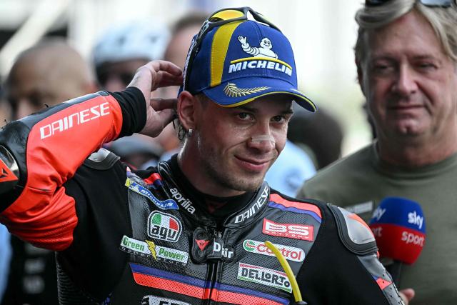 TOPSHOT - Aprilia Racing's Italian rider Marco Bezzecchi looks on as he celebrates taking pole position in the qualifying session of the MotoGP Thailand Grand Prix at the Buriram International Circuit in Buriram on February 28, 2026. (Photo by Lillian SUWANRUMPHA / AFP)