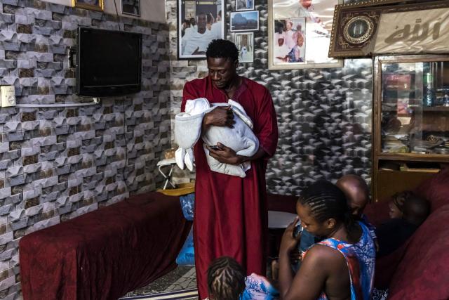 Doudou Sene holds his newborn baby Mohamed at his home in Dakar, on February 27, 2026. What started as small workouts in one of the many outdoor gyms that proliferate in Dakar slowly turned into a passion for Doudou Sene. People kept telling him that he had potential in the world of fitness, and in 2019 he began to train seriously. In 2021, he participated in his first powerlifting competition in Dakar and finished first in the under?83 kg category. Soon after, he traveled to The Gambia for another competition, where he finished third. After succeeding as a powerlifter, he decided to switch to bodybuilding, a little?known sport in Senegal with few role models, such as Sidy Pouye, who has managed to build a successful career abroad as a bodybuilder. People dont know much about the sport, but that doesnt stop Doudou from following his passion. During the holy month of Ramadan, training and maintaining a proper diet become challenging. Doudou normally eats five to six meals a day to maintain his gains, but during Ramadan this is reduced to two or three. He prefers to train at the gym where he works right before breaking the fast, and then stays late to help clients with their workouts. Family and religion are his driving forces as he continues pushing himself, even during Ramadan, to achieve his goal of making a living as a bodybuilder and providing for his family. (Photo by PATRICK MEINHARDT / AFP)