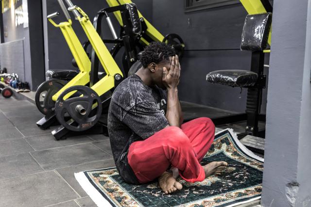 Doudou Sene prays after breaking his fast at a gym during the holy month of Ramadan in Dakar, on February 23, 2026. What started as small workouts in one of the many outdoor gyms that proliferate in Dakar slowly turned into a passion for Doudou Sene. People kept telling him that he had potential in the world of fitness, and in 2019 he began to train seriously. In 2021, he participated in his first powerlifting competition in Dakar and finished first in the under?83 kg category. Soon after, he traveled to The Gambia for another competition, where he finished third. After succeeding as a powerlifter, he decided to switch to bodybuilding, a little?known sport in Senegal with few role models, such as Sidy Pouye, who has managed to build a successful career abroad as a bodybuilder. People dont know much about the sport, but that doesnt stop Doudou from following his passion. During the holy month of Ramadan, training and maintaining a proper diet become challenging. Doudou normally eats five to six meals a day to maintain his gains, but during Ramadan this is reduced to two or three. He prefers to train at the gym where he works right before breaking the fast, and then stays late to help clients with their workouts. Family and religion are his driving forces as he continues pushing himself, even during Ramadan, to achieve his goal of making a living as a bodybuilder and providing for his family. (Photo by PATRICK MEINHARDT / AFP)