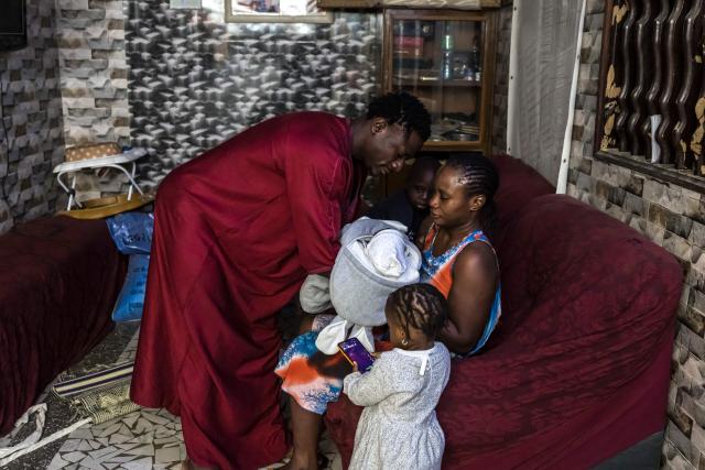 Doudou Sene (L) holds his newborn baby Mohamed at his home in Dakar, on February 27, 2026. What started as small workouts in one of the many outdoor gyms that proliferate in Dakar slowly turned into a passion for Doudou Sene. People kept telling him that he had potential in the world of fitness, and in 2019 he began to train seriously. In 2021, he participated in his first powerlifting competition in Dakar and finished first in the under?83 kg category. Soon after, he traveled to The Gambia for another competition, where he finished third. After succeeding as a powerlifter, he decided to switch to bodybuilding, a little?known sport in Senegal with few role models, such as Sidy Pouye, who has managed to build a successful career abroad as a bodybuilder. People dont know much about the sport, but that doesnt stop Doudou from following his passion. During the holy month of Ramadan, training and maintaining a proper diet become challenging. Doudou normally eats five to six meals a day to maintain his gains, but during Ramadan this is reduced to two or three. He prefers to train at the gym where he works right before breaking the fast, and then stays late to help clients with their workouts. Family and religion are his driving forces as he continues pushing himself, even during Ramadan, to achieve his goal of making a living as a bodybuilder and providing for his family. (Photo by PATRICK MEINHARDT / AFP)