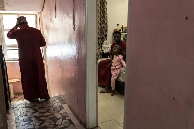 Doudou Sene (R) plays with one of his nieces at his home as he gets ready for the Friday prayer during the holy month of Ramadan in Dakar, on February 27, 2026. What started as small workouts in one of the many outdoor gyms that proliferate in Dakar slowly turned into a passion for Doudou Sene. People kept telling him that he had potential in the world of fitness, and in 2019 he began to train seriously. In 2021, he participated in his first powerlifting competition in Dakar and finished first in the under?83 kg category. Soon after, he traveled to The Gambia for another competition, where he finished third. After succeeding as a powerlifter, he decided to switch to bodybuilding, a little?known sport in Senegal with few role models, such as Sidy Pouye, who has managed to build a successful career abroad as a bodybuilder. People dont know much about the sport, but that doesnt stop Doudou from following his passion. During the holy month of Ramadan, training and maintaining a proper diet become challenging. Doudou normally eats five to six meals a day to maintain his gains, but during Ramadan this is reduced to two or three. He prefers to train at the gym where he works right before breaking the fast, and then stays late to help clients with their workouts. Family and religion are his driving forces as he continues pushing himself, even during Ramadan, to achieve his goal of making a living as a bodybuilder and providing for his family. (Photo by PATRICK MEINHARDT / AFP)