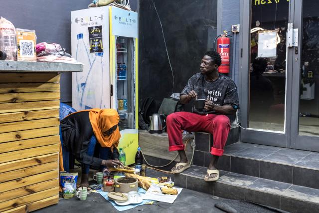 TOPSHOT - Doudou Sene (R) breaks his fast with a colleague at a gym during the holy month of Ramadan in Dakar, on February 23, 2026. What started as small workouts in one of the many outdoor gyms that proliferate in Dakar slowly turned into a passion for Doudou Sene. People kept telling him that he had potential in the world of fitness, and in 2019 he began to train seriously. In 2021, he participated in his first powerlifting competition in Dakar and finished first in the under?83 kg category. Soon after, he traveled to The Gambia for another competition, where he finished third. After succeeding as a powerlifter, he decided to switch to bodybuilding, a little?known sport in Senegal with few role models, such as Sidy Pouye, who has managed to build a successful career abroad as a bodybuilder. People dont know much about the sport, but that doesnt stop Doudou from following his passion. During the holy month of Ramadan, training and maintaining a proper diet become challenging. Doudou normally eats five to six meals a day to maintain his gains, but during Ramadan this is reduced to two or three. He prefers to train at the gym where he works right before breaking the fast, and then stays late to help clients with their workouts. Family and religion are his driving forces as he continues pushing himself, even during Ramadan, to achieve his goal of making a living as a bodybuilder and providing for his family. (Photo by PATRICK MEINHARDT / AFP)