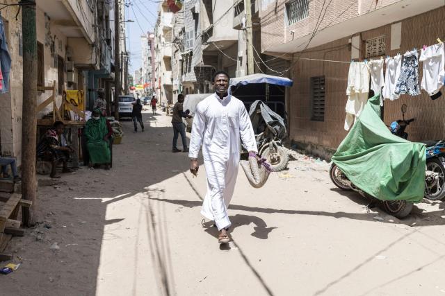Doudou Sene walks to the mosque ahead of the Friday prayer during the holy month of Ramadan in Dakar, on February 27, 2026. What started as small workouts in one of the many outdoor gyms that proliferate in Dakar slowly turned into a passion for Doudou Sene. People kept telling him that he had potential in the world of fitness, and in 2019 he began to train seriously. In 2021, he participated in his first powerlifting competition in Dakar and finished first in the under?83 kg category. Soon after, he traveled to The Gambia for another competition, where he finished third. After succeeding as a powerlifter, he decided to switch to bodybuilding, a little?known sport in Senegal with few role models, such as Sidy Pouye, who has managed to build a successful career abroad as a bodybuilder. People dont know much about the sport, but that doesnt stop Doudou from following his passion. During the holy month of Ramadan, training and maintaining a proper diet become challenging. Doudou normally eats five to six meals a day to maintain his gains, but during Ramadan this is reduced to two or three. He prefers to train at the gym where he works right before breaking the fast, and then stays late to help clients with their workouts. Family and religion are his driving forces as he continues pushing himself, even during Ramadan, to achieve his goal of making a living as a bodybuilder and providing for his family. (Photo by PATRICK MEINHARDT / AFP)