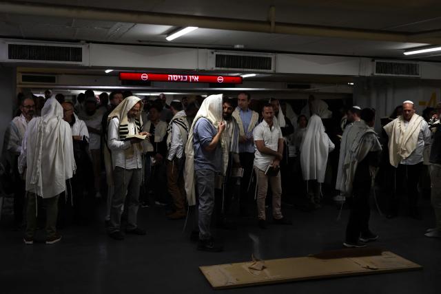 Jews pray as they take shelter in Tel Aviv on February 28, 2026. The Israeli military said its strikes on Iran, in coordination with the United States, targeted dozens of military sites and followed months of joint planning between the allies. (Photo by ilia YEFIMOVICH / AFP)