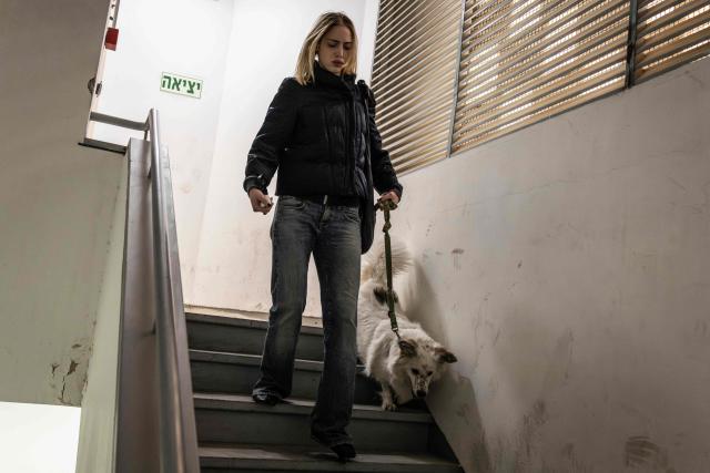 A woman enters a shelter with her dog as sirens sound in Jerusalem on February 28, 2026. The United States and Israel launched a wave of strikes against targets in Iranian cities on February 28, triggering explosions and columns of smoke in the capital Tehran. Iran responded by launching retaliatory missile attacks, according to the Israeli military, as US diplomats in the Gulf and Israeli civilians were ordered to seek shelter. (Photo by John WESSELS / AFP)