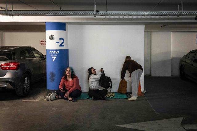 People take shelter in a underground parking as sirens sound in Jerusalem on February 28, 2026. The United States and Israel launched a wave of strikes against targets in Iranian cities on February 28, triggering explosions and columns of smoke in the capital Tehran. Iran responded by launching retaliatory missile attacks, according to the Israeli military, as US diplomats in the Gulf and Israeli civilians were ordered to seek shelter. (Photo by John WESSELS / AFP)