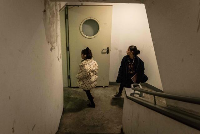 Two young girls run into a shelter as sirens sound in Jerusalem on February 28, 2026. The United States and Israel launched a wave of strikes against targets in Iranian cities on February 28, triggering explosions and columns of smoke in the capital Tehran. Iran responded by launching retaliatory missile attacks, according to the Israeli military, as US diplomats in the Gulf and Israeli civilians were ordered to seek shelter. (Photo by John WESSELS / AFP)
