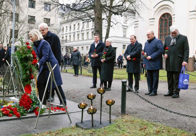On the 40th anniversary of former Swedish Social Democratic Party chairman and Prime Minister Olof Palme's assassination, (L-R) current Swedish Social Democratic Party chairman Magdalena Andersson and former Ingvar Carlsson lay a wreath at Olof Palme's grave as party secretary Tobias Baudin and former party chairmen Mona Sahlin, former Swedish Prime Ministers Stefan Lofven and Goran Persson and former Social Democratic Party chairman Hakan Juholt stand at the Adolf Fredrik's cemetery in Stockholm, Sweden on 28 February 2026. Swedish Prime Minister and Party leader of the Social Democratic party Olof Palme was assassinated on February 28, 1986 on Sveavagen street in the center of Stockholm. (Photo by Fredrik PERSSON / TT NEWS AGENCY / AFP) / Sweden OUT