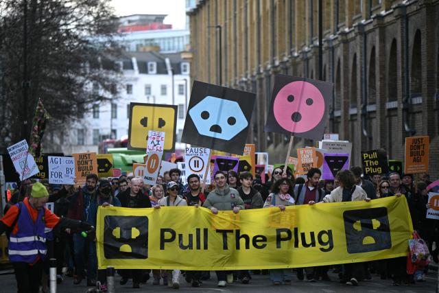 Protesters march behind a large banner at a protest organized by PauseAI UK and other groups concerned in controlling the development of advanced Artificial Intelligence systems, in London on February 28, 2026. (Photo by JUSTIN TALLIS / AFP)