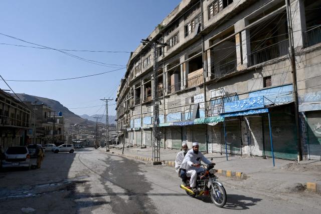 Men ride a bike past the closed Landi Kotal Bazaar near the Torkham border between Afghanistan and Pakistan on February 28, 2026, amidst the ongoing clashes between the two countries. Afghanistan said it downed a Pakistan fighter jet and captured its pilot on February 28, a claim denied by Islamabad a day after it declared an "open war" with its South Asian neighbour. (Photo by Abdul MAJEED / AFP)