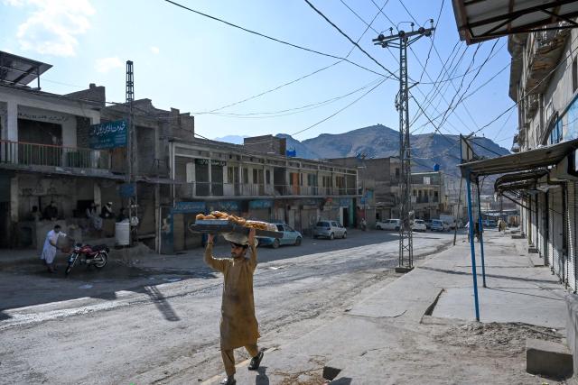 A vendor walks past the closed Landi Kotal Bazaar near the Torkham border between Afghanistan and Pakistan on February 28, 2026, amidst the ongoing clashes between the two countries. Afghanistan said it downed a Pakistan fighter jet and captured its pilot on February 28, a claim denied by Islamabad a day after it declared an "open war" with its South Asian neighbour. (Photo by Abdul MAJEED / AFP)