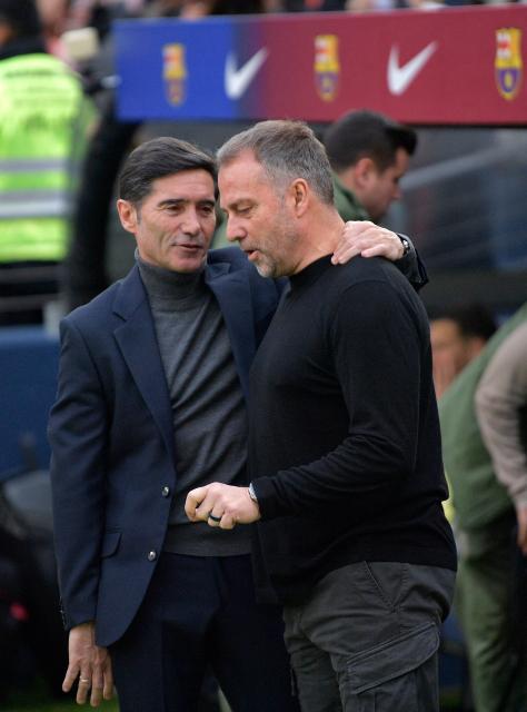 Villarreal's Spanish coach Marcelino Garcia Toral (L) speaks with Barcelona's German coach Hans-Dieter Flick before the Spanish league football match between FC Barcelona and Villarreal CF at Camp Nou Stadium in Barcelona on February 28, 2026. (Photo by MANAURE QUINTERO / AFP)
