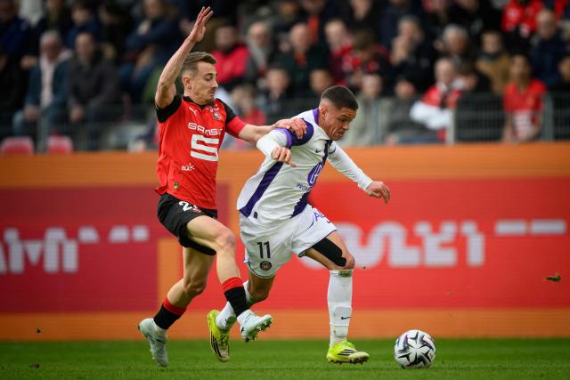 Toulouse's Argentinian forward #11 Santiago Hidalgo fights for the ball with Rennes' French midfielder #21 Valentin Rongier during the French L1 football match between Stade Rennais and Toulouse FC at the Roazhon Park stadium in Rennes, western France on February 28, 2026. (Photo by Loic VENANCE / AFP)