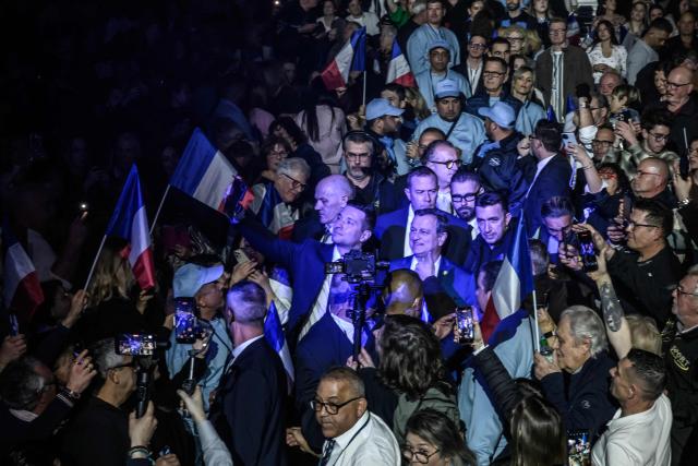 President of French far-right party Rassemblement National (RN) Jordan Bardella (C-L) and RN candidate for his reelection in Perpignan Louis Aliot (C-R) take a selfie with supporters as they arrive to a rally ahead of France's municipal elections, in Perpignan, southern France on February 28, 2026. French voters head to the polls for municipal elections on March 15 and 22, 2026. (Photo by Ed JONES / AFP)