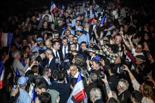 President of French far-right party Rassemblement National (RN) Jordan Bardella (C-L) arrives at a rally in support of RN candidate for his reelection in Perpignan Louis Aliot ahead of France's municipal elections, in Perpignan, southern France on February 28, 2026. French voters head to the polls for municipal elections on March 15 and 22, 2026. (Photo by Ed JONES / AFP)