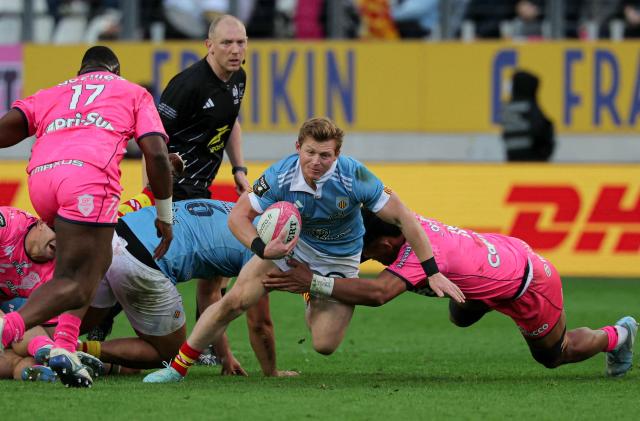 Perpignan's British scrum-half James Hall (C) is tackled by Stade Francais' Tongan flanker Tanginoa Palu Halaifonua (R) during the French Top14 rugby union match between Stade Francais Paris and USA Perpignan at the Jean-Bouin Stadium in Paris on February 28, 2026. (Photo by Thomas SAMSON / AFP)
