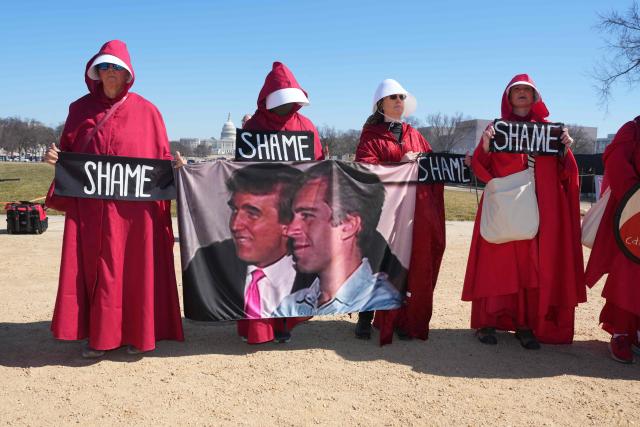 Demonstrators dressed as handmaids from The Handmaid's Tale hold a sign showing a photo of US President Donald Trump and Jeffrey Epstein during a "March 4 Democracy" protest in Washington, DC, on February 28, 2026. The United States and Israel launched what the latter called a "decisive and unprecedented" campaign against Iran, which retaliated with a barrage of missiles that sent residents running for cover on Saturday in cities across the Middle East. (Photo by Ken Cedeno / AFP)