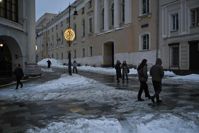 Pedestrians walk on a street in central Moscow on February 28, 2026. (Photo by HECTOR RETAMAL / AFP)