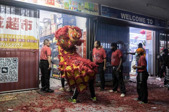 TOPSHOT - Performers take part in a traditional Chinese lion dance outside a shop during the celebrations of  the Chinese New Year, marking the beginning of the Year of the Fire Horse in Cyrildene, Johannesburg on February 28, 2026. (Photo by ILARIA FINIZIO / AFP)