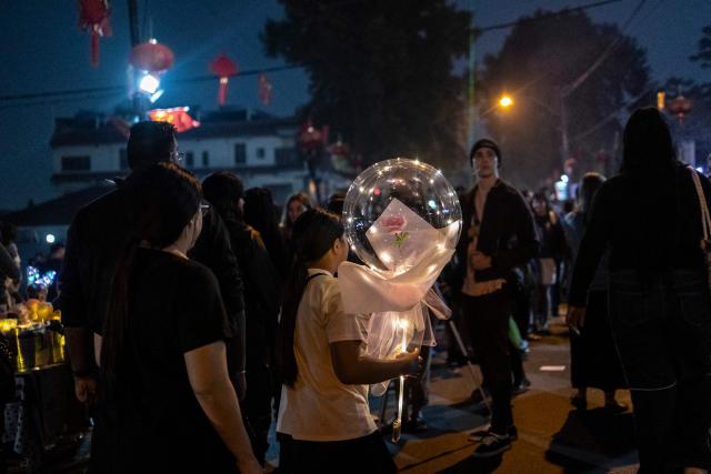 A young girl carries a balloon containing a flower during celebrations of the Chinese New Year, marking the beginning of the Year of the Fire Horse in Cyrildene, Johannesburg on February 28, 2026. (Photo by ILARIA FINIZIO / AFP)