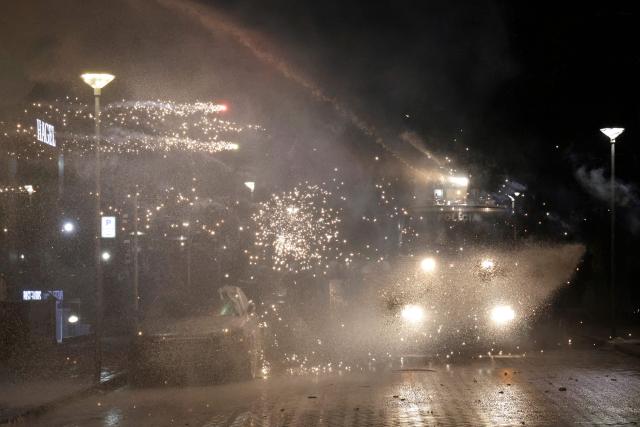 Protesters shoot fireworks towards a police water canon during an anti-government protest in Tirana on February 28, 2026.  (Photo by Adnan Beci / AFP)