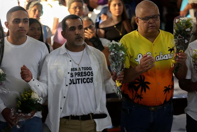 Former political prisoners (front row) participate in a Mass for freedom in Maiquetia, La Guaira State, Venezuela, on February 28, 2026. (Photo by Pedro MATTEY / AFP)