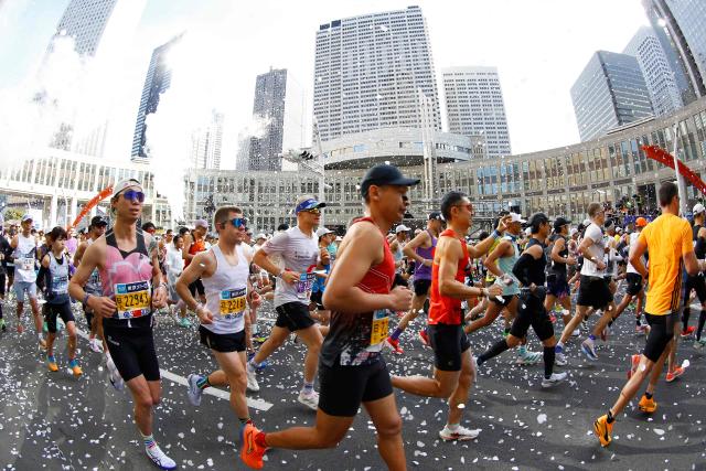 A fish-eye view shows runners setting off in front of the Tokyo Metropolitan Government building at the start of the Tokyo Marathon in the Shinjuku area of downtown Tokyo on March 1, 2026. (Photo by Rodrigo Reyes Marin / POOL / AFP)