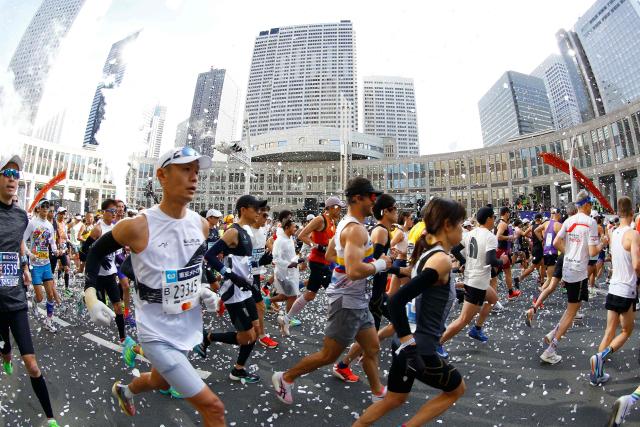 A fish-eye view shows runners setting off in front of the Tokyo Metropolitan Government building at the start of the Tokyo Marathon in the Shinjuku area of downtown Tokyo on March 1, 2026. (Photo by Rodrigo Reyes Marin / POOL / AFP)
