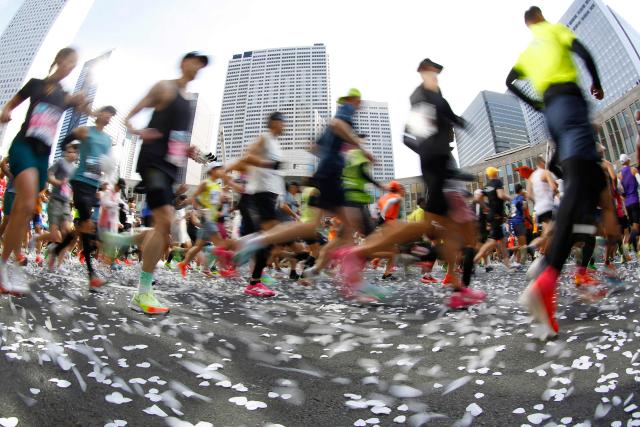 A fisheye lens view shows runners setting off in front of the Tokyo Metropolitan Government building at the start of the Tokyo Marathon in the Shinjuku area of downtown Tokyo on March 1, 2026. (Photo by Rodrigo Reyes Marin / POOL / AFP)