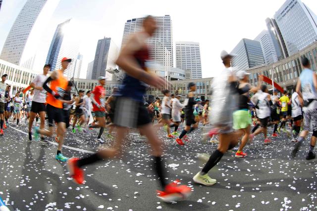 A fisheye lens view shows runners setting off in front of the Tokyo Metropolitan Government building at the start of the Tokyo Marathon in the Shinjuku area of downtown Tokyo on March 1, 2026. (Photo by Rodrigo Reyes Marin / POOL / AFP)