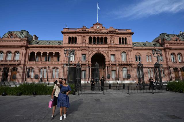 A woman takes a selfie in front of presidential palace Casa Rosada in Buenos Aires on February 28, 2026. Argentina went on high alert on February 28 after the US and Israeli attacks on Iran and the latter's retaliatory strikes. The heightened alert in Argentina involves "all the country's sensitive targets, critical infrastructure and the Jewish community," President Javier Milei's office said in a statement. (Photo by Luis ROBAYO / AFP)